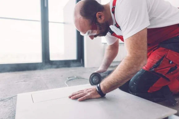 Person schneidet Fliese mit Trennschleifer